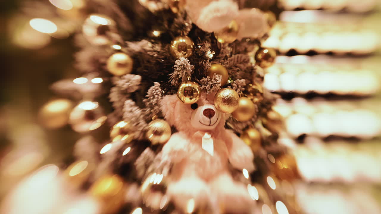 A softly lit Christmas tree decorated with gold baubles and warm fairy lights
