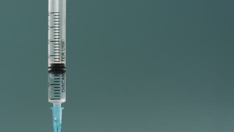 Video-of-close-up-of-vaccine-vials-on-green-background