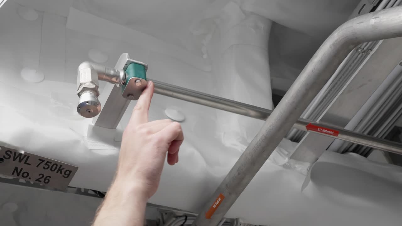 el capitán muestra el sistema de aspersión de niebla de agua en el área de la sala de máquinas de los barcos, de cerca