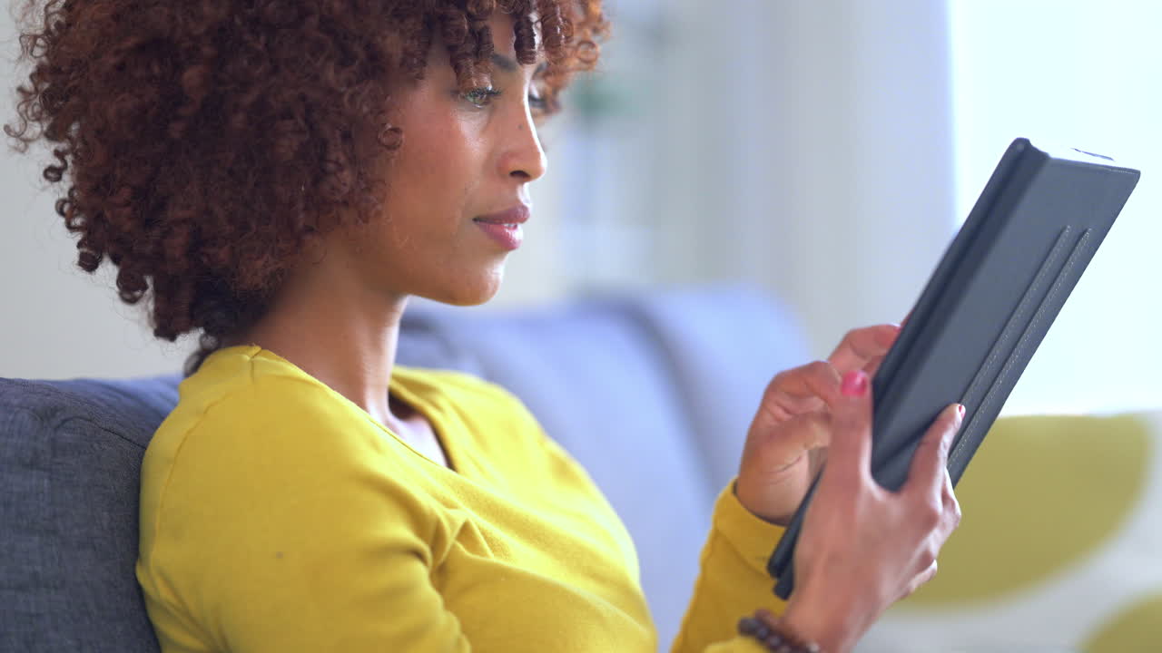 A trendy young woman texting on a digital tablet