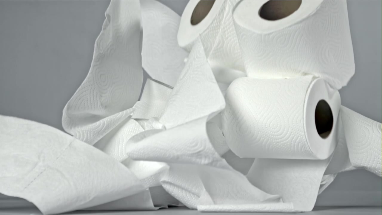 Multiple Rolls of Paper Towels Falling and Unrolling in Slow Motion