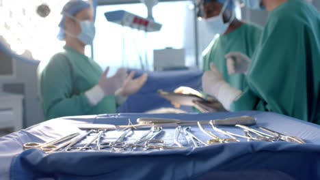 diverse female and male surgeons in masks in discussion during operation, slow motion