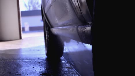 using the wand sprayer at a car wash to clean off the bottom section of a jeep