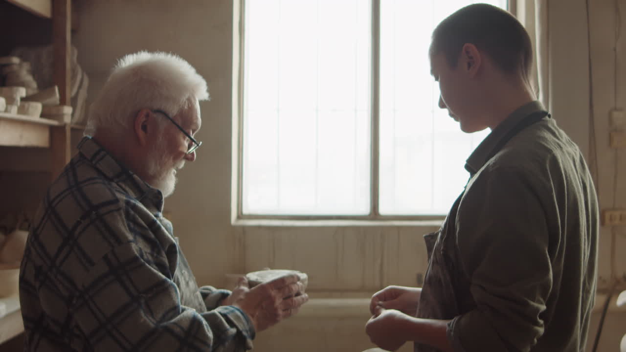 수석 도자기 가 작업실 에서 젊은 여자 를 가르치고 있다