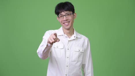 young asian businessman smiling and pointing to camera