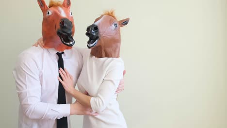 a man and a woman in a horse mask are dancing and having fun on a light background a man and a woman in a horse mask are dancing and having fun on a light background funny couple having fun