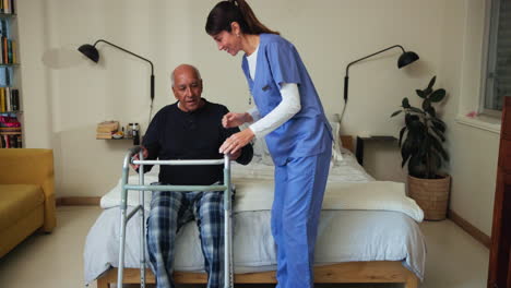 nurse helping senior citizen get out of bed with a walker