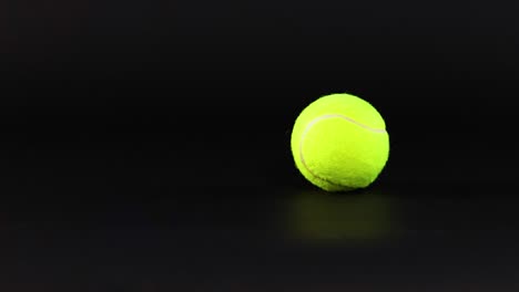 a tennis ball moves across a dark surface, captured in sequential frames.
