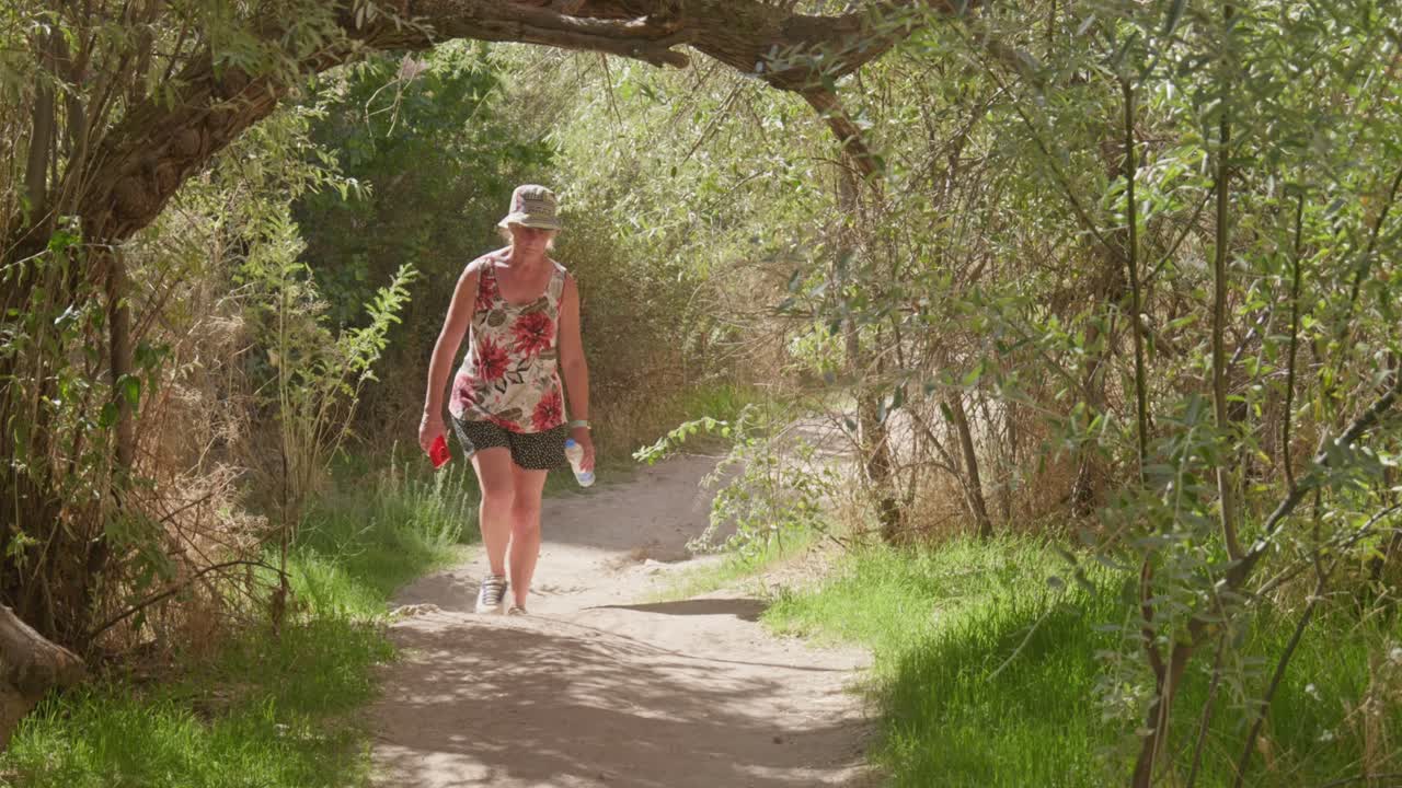verano mujer vestida casualmente caminante explora el sendero de la naturaleza día soleado