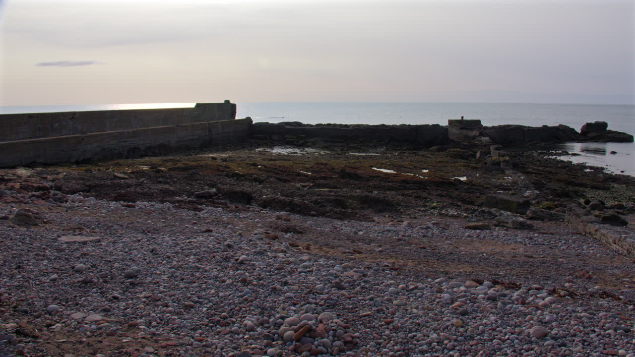 Wide shot of the old harbour and beach at Auchmithie, Arbroath