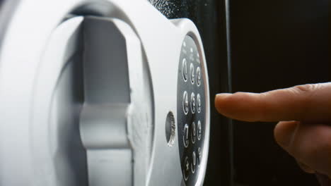 Fingers-pressing-code-safe-electronic-panel-close-up.-Man-entering-password.