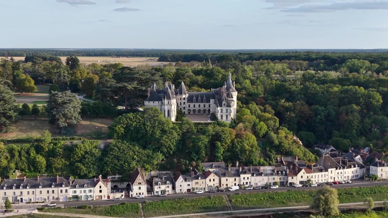 Riprese aeree inquadrano il Château de Chaumont-sur-Loire sopra un borgo storico lungo il fiume, con terreni boscosi, campi coltivati e il paesaggio della Valle della Loira che si estende verso l'orizzonte