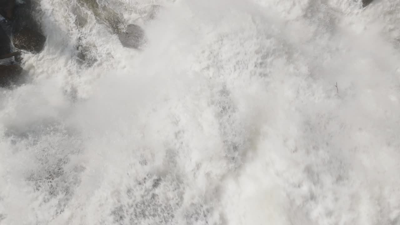 el agua corriente fluye sobre las rocas en el sonido de owen, creando una poderosa exhibición de espuma blanca.