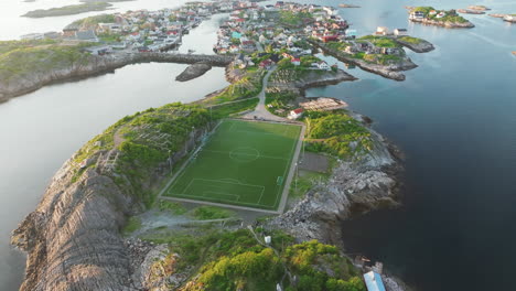 fantastic aerial view at mid-altitude and in orbit over the famous henningsvaer football field on the lofoten islands during sunset with beautiful colors. norway.
