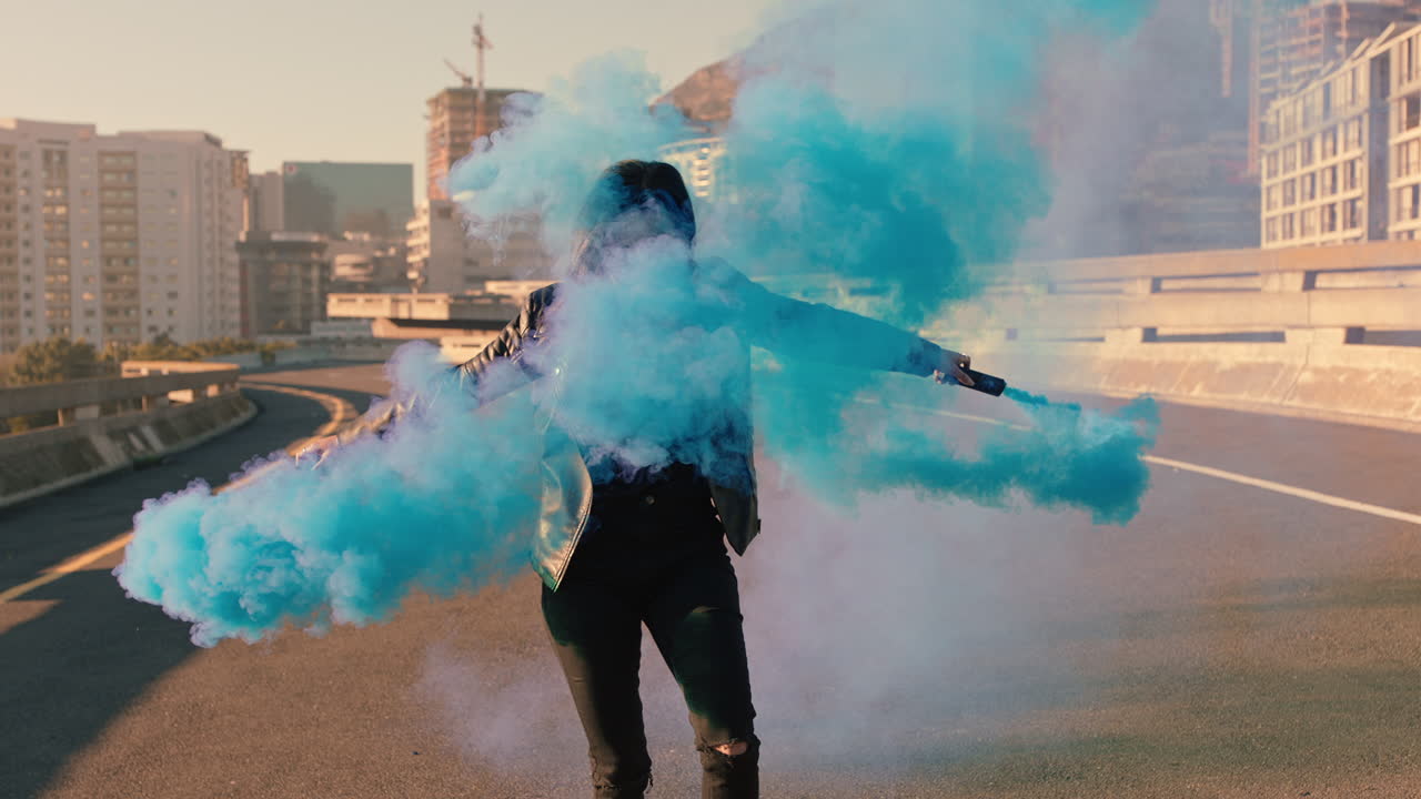 chica bailando con granada de humo azul en la ciudad joven bailarina celebrando la expresión creativa con el hip hop bailando en la calle en cámara lenta