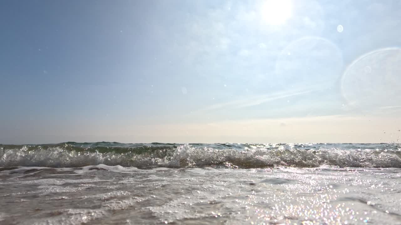 바다의 파도가 모래 해변에 부드럽게 부히고