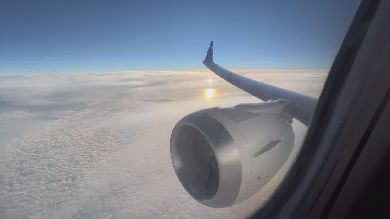 vista por la ventana del avión al amanecer o al atardecer sobre las nubes