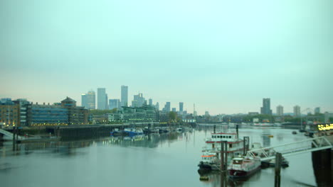 winter view of city of london financial district, canary wharf with river thames