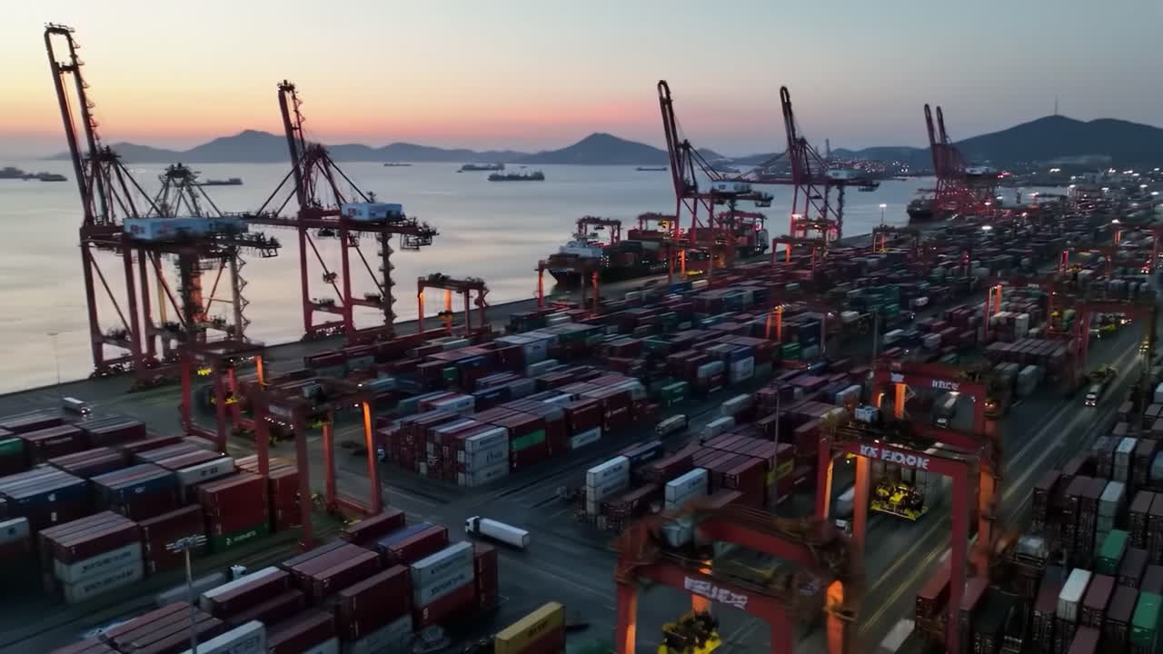 Aerial View of a Busy Shipping Port at Dusk with Container Stacks, Cranes, and Ships in the Harbor, Showcasing Maritime Cargo Operations and Logistics