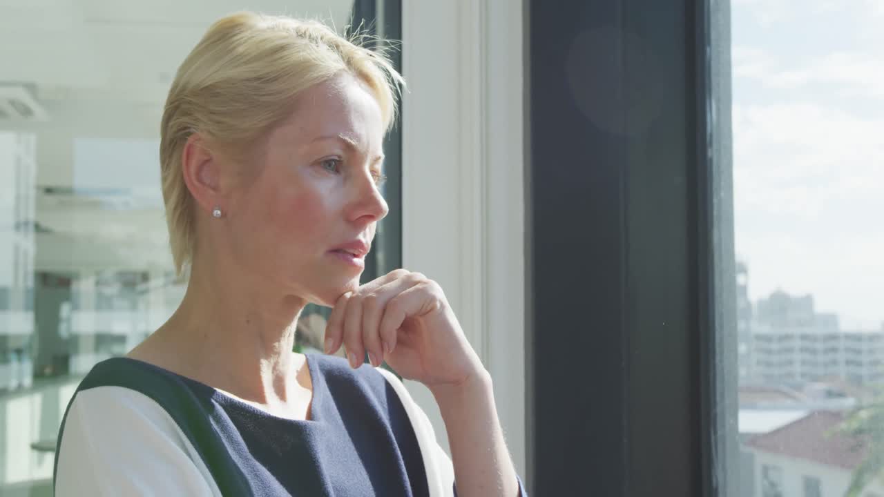 Business woman thoughtful looking through the window