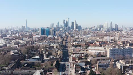 Dolly-forward-drone-shot-towards-city-of-London-skyscraper-cluster-over-Whitechapel-road