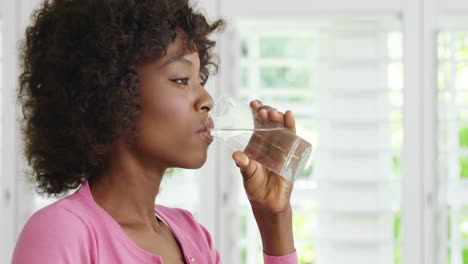 woman drinking glass of water and smiling