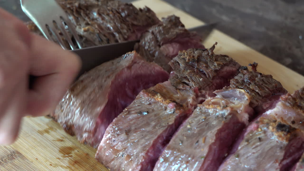 Woman cutting up a piece of red meat on a wooden cutting board