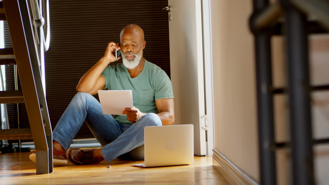 Senior man talking on mobile phone at home 4k