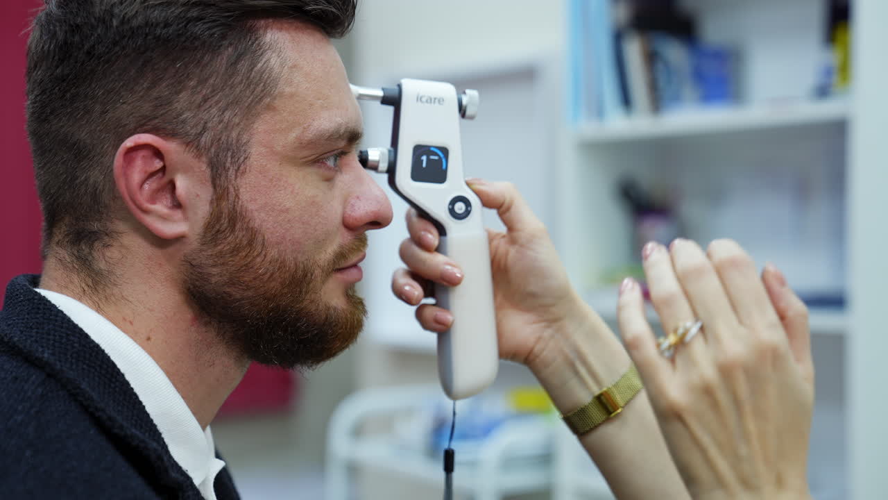 Young man checking up vision. Female ophthalmologist doing eye exam of young man