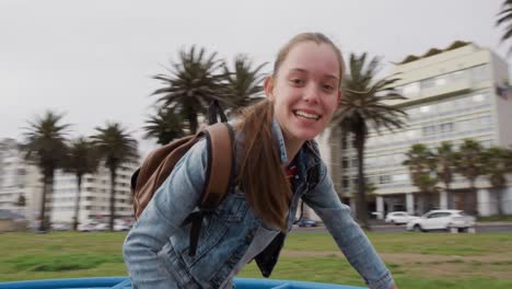 Front-view-of-a-Caucasian-girl-on-a-merry-go-round-looking-at-camera