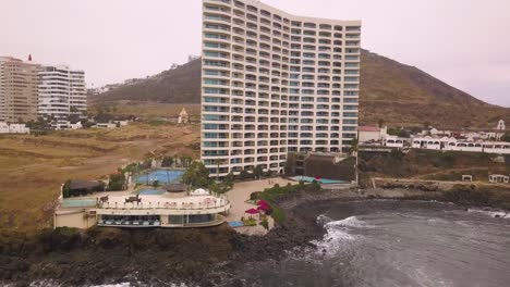 disparado alejándose de un gran hotel con una piscina en las orillas del mar en méxico