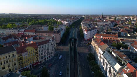 elevated train navigating through a residential area in berlin, showcasing the city's urban transportation system. best aerial view flight ascending drone