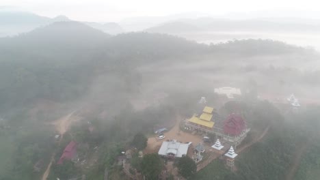 aerial footage of wat su tong pae, famous temple in mae hong son, thailand in foggy weather