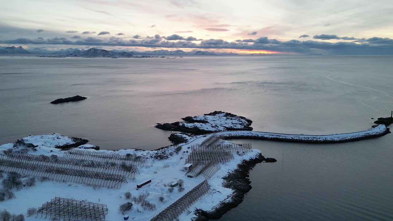 Snowy coastal landscape at Svinøya with calm waters and a serene winter atmosphere