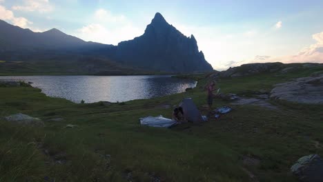 timelapse of two hikers setting tent in anayet mountain range peak and lake in spanish pyrenees