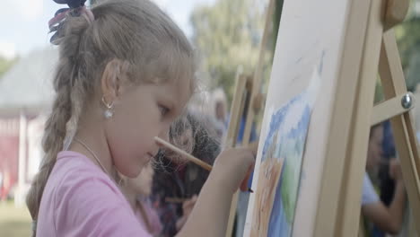 young girl painting outdoors