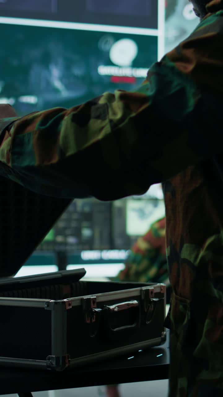 Vertical Video Government intelligence expert works on laptop in a command center