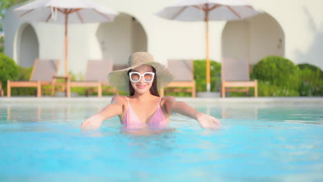 Mujer-Exótica-Feliz-Jugando-Con-Agua-En-La-Piscina-Del-Complejo-Hotelero-De-Lujo