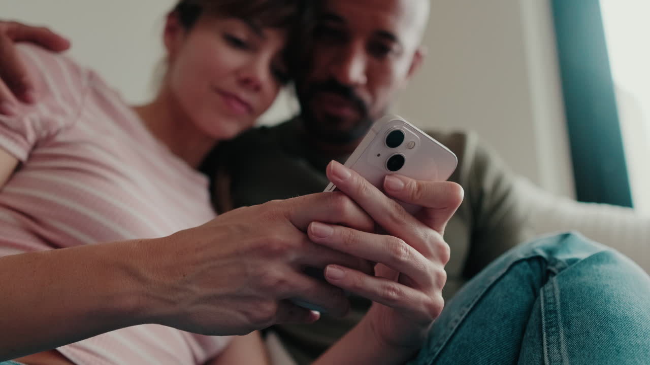 Couple At Home Browsing Smartphone Together