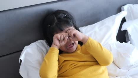 little girl playing and smiling on a bed