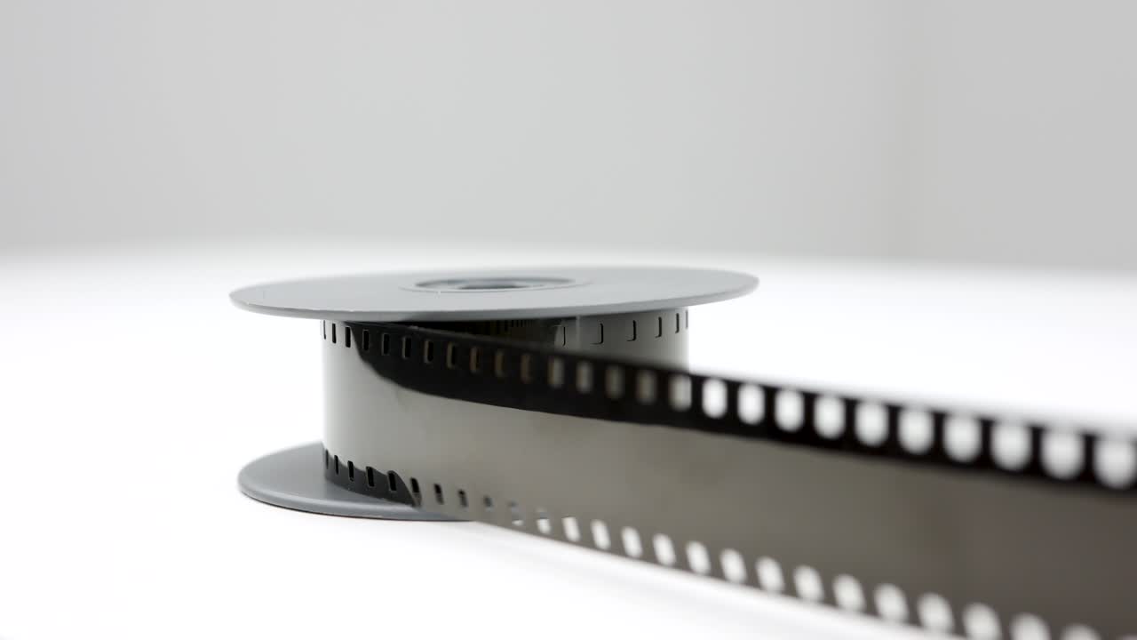 흰색 테이블에 있는 오래된 8mm 빈티지 필름, 왼쪽에서 오른쪽으로 느린 팬