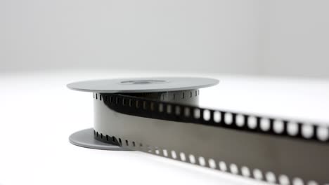 película antigua de 8 mm sobre mesa blanca, panorámica lenta de izquierda a derecha