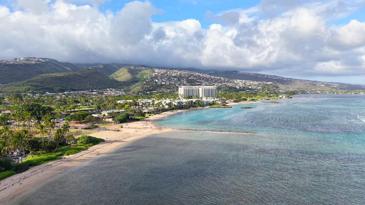 The Kahala Hotel on a sandy beach with palm trees in Honolulu Hawaii, aerial