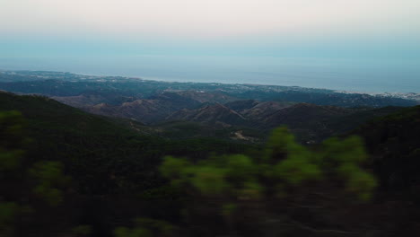 A-drone-aerial-pans-over-treetops-looking-out-to-the-shoreline-of-Estepona,-Spain