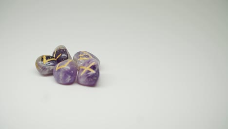 Five-Purple-Colored-Gem-Stones-With-Yellow-Mark-On-The-top-Of-each-stone-Rotating-On-A-Turntable---Close-Up-Shot