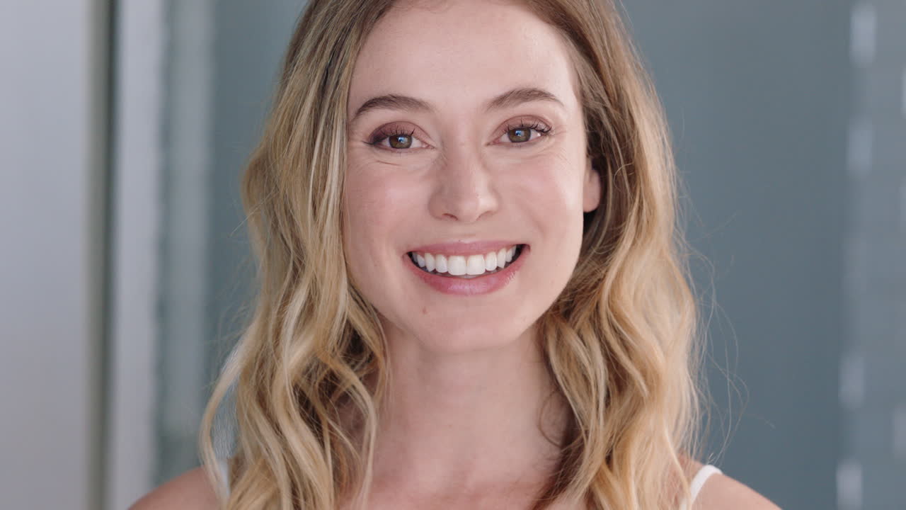 retrato de una hermosa mujer caucásica mirándose en el espejo con una piel perfecta disfrutando de una tez natural sonriendo con confianza preparándose en casa