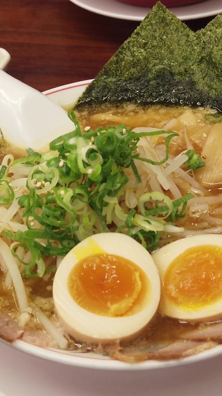 Ramen giapponese fumante con uovo sodo e noodles in primo piano. Comfort food