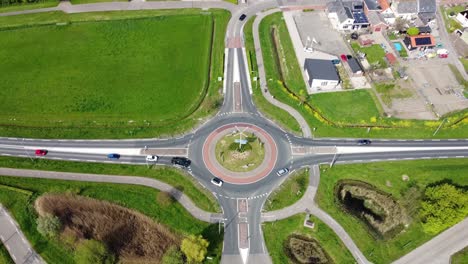 Kreisverkehr-In-Den-Niederlanden,-Umgeben-Von-Grünen-Feldern-Und-Ein-Paar-Häusern