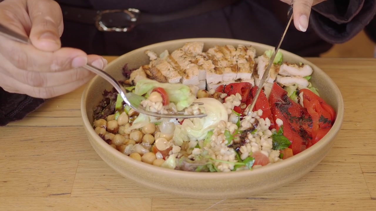 Person Eating a Healthy Grilled Chicken Salad Bowl