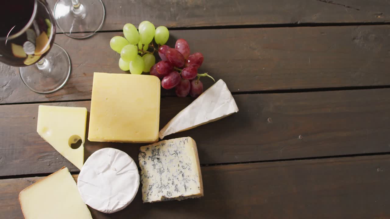 나무 표면 에 있는 다양한 치즈, 포도, 와인 잔 의 비디오